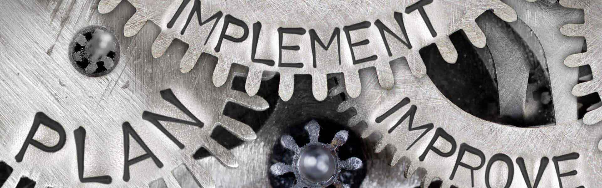 Cogs with Plan, Implement and Improve written on them